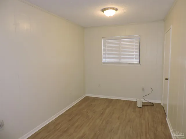 a view of a room with wooden floor and white walls