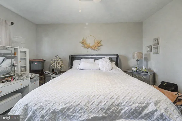 a bedroom with a bed a tv and wooden floor