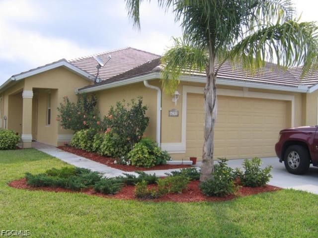 4791 Fairloop Run Lehigh Acres, FL 33973 - Photo 1 of 19 a front view of a house with garden