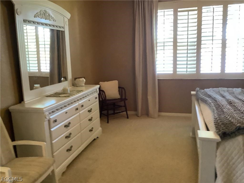 4791 Fairloop Run Lehigh Acres, FL 33973 - Photo 12 of 19 a bedroom with a bed and a window