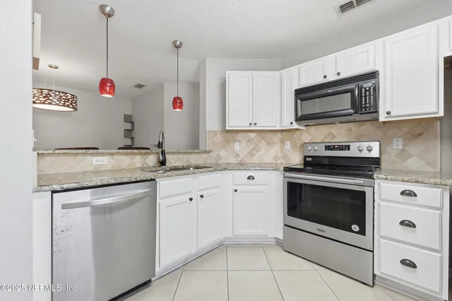 a kitchen with granite countertop cabinets stainless steel appliances and a sink