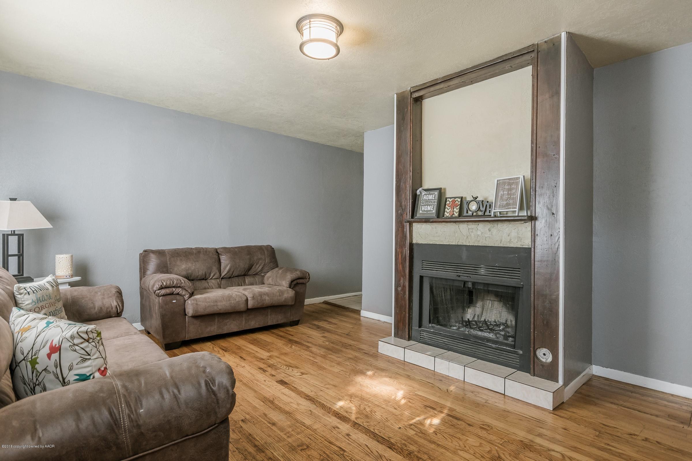 4635 South Hughes Street Amarillo, TX 79110 - Photo 2 of 20 a living room with furniture and a fireplace