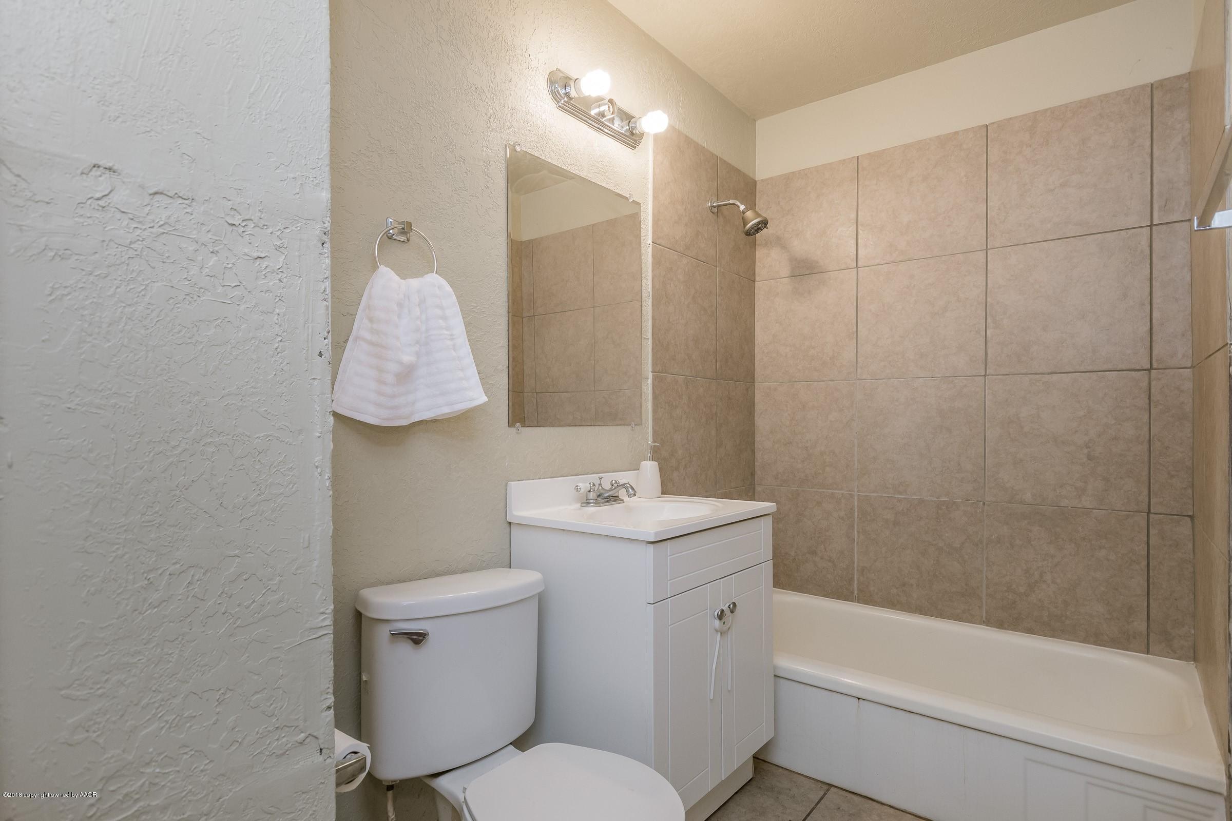 4635 South Hughes Street Amarillo, TX 79110 - Photo 16 of 20 a bathroom with a sink toilet and shower