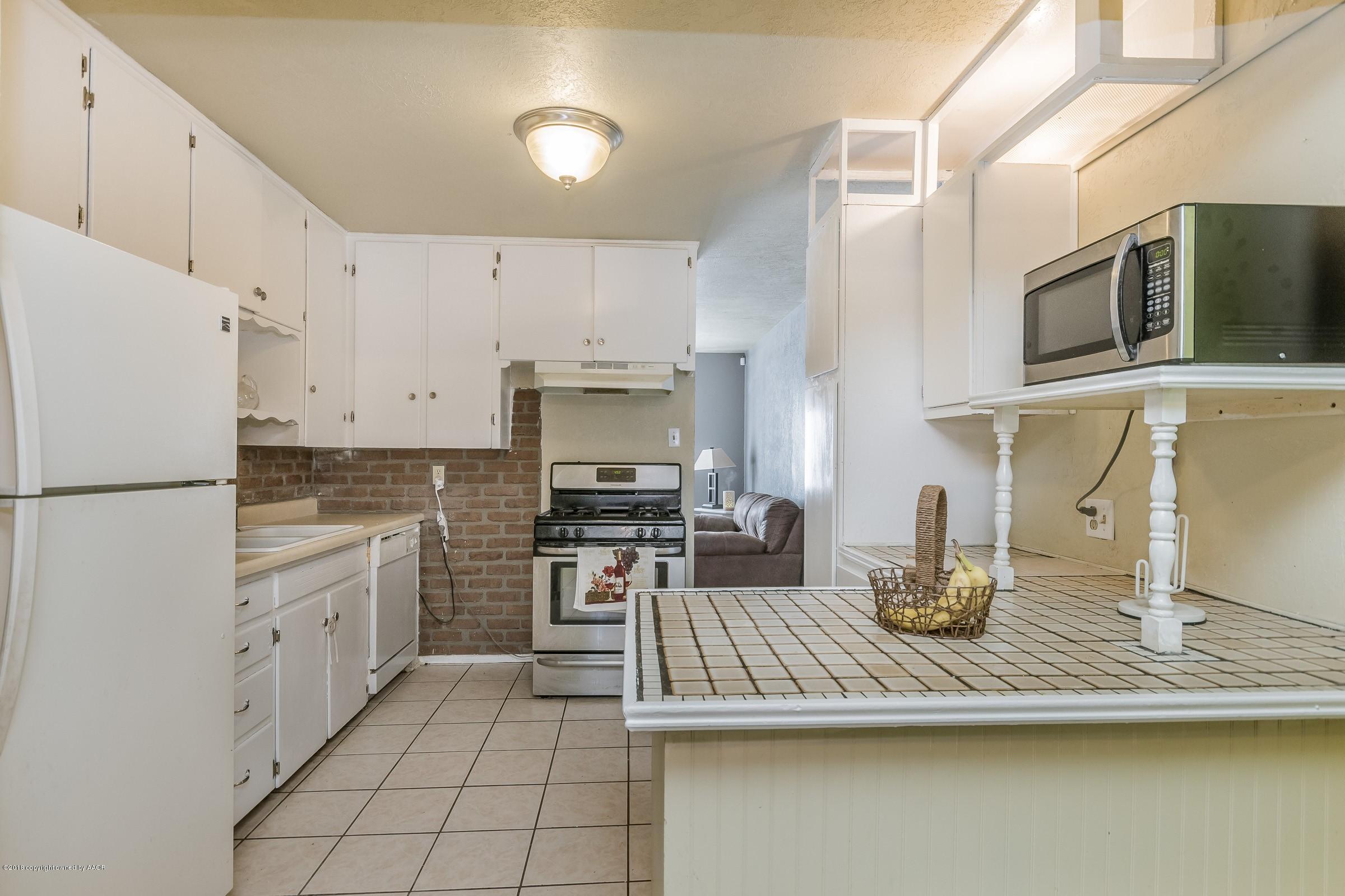 4635 South Hughes Street Amarillo, TX 79110 - Photo 4 of 20 a kitchen with stainless steel appliances granite countertop a sink stove and refrigerator