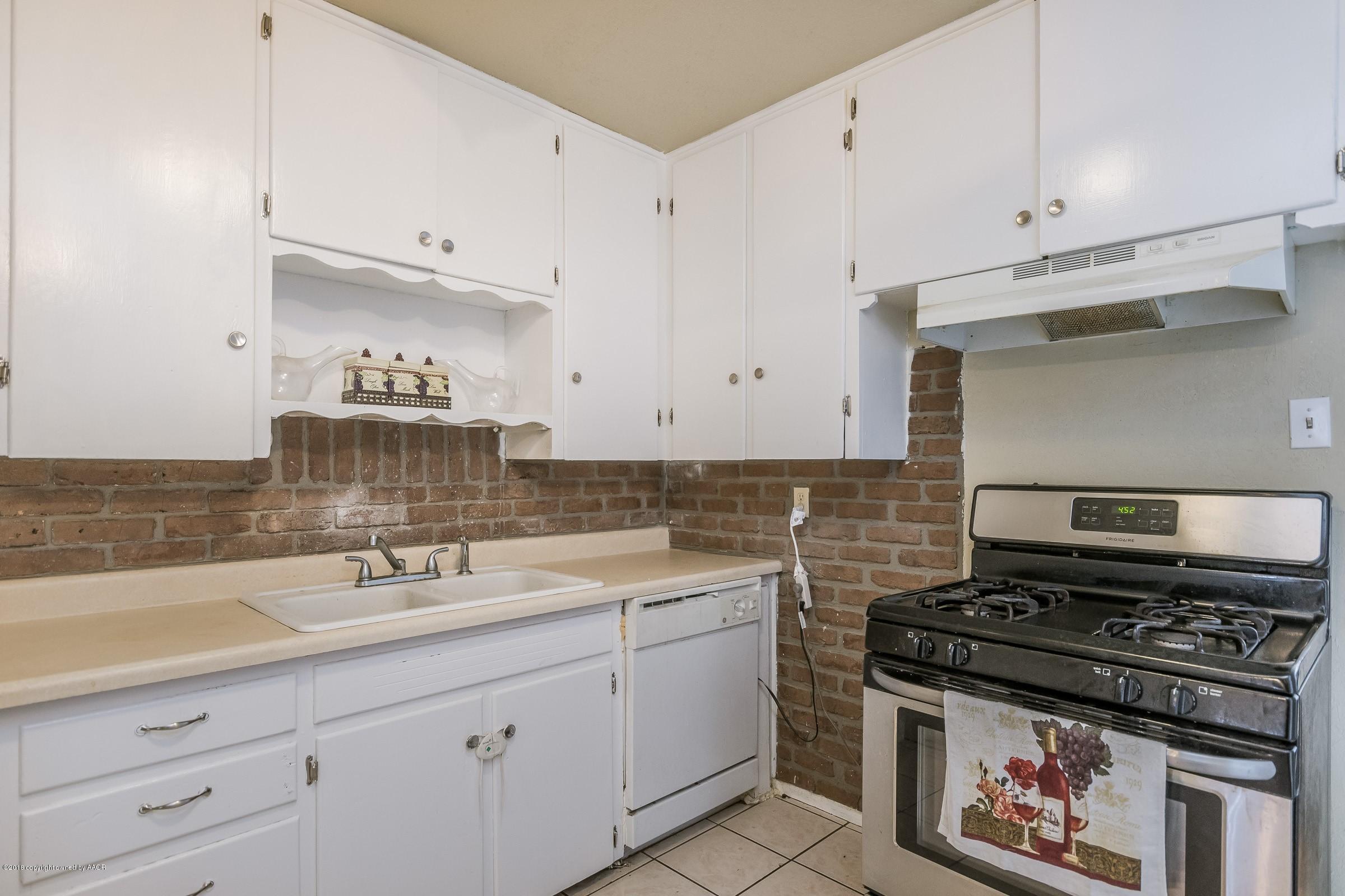 4635 South Hughes Street Amarillo, TX 79110 - Photo 5 of 20 a kitchen with a sink stove and cabinets