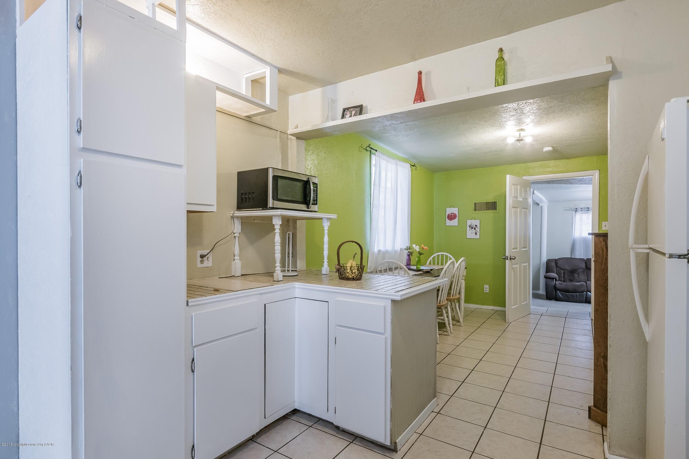 4635 South Hughes Street Amarillo, TX 79110 - Photo 6 of 20 a kitchen with a refrigerator and sink