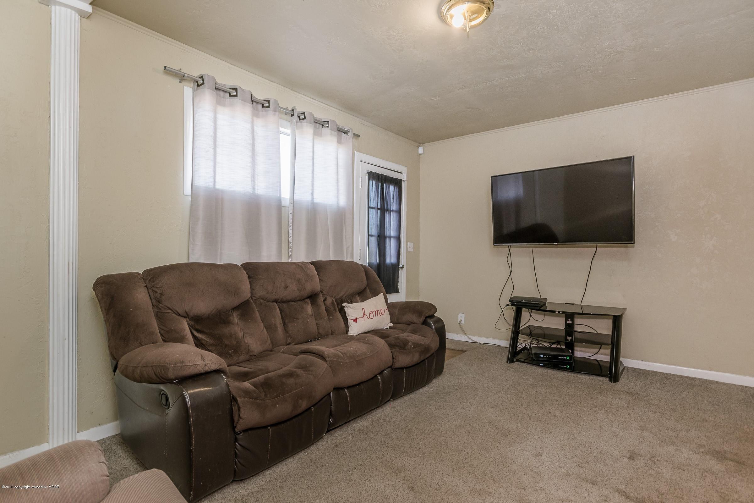 4635 South Hughes Street Amarillo, TX 79110 - Photo 8 of 20 a living room with furniture and a flat screen tv