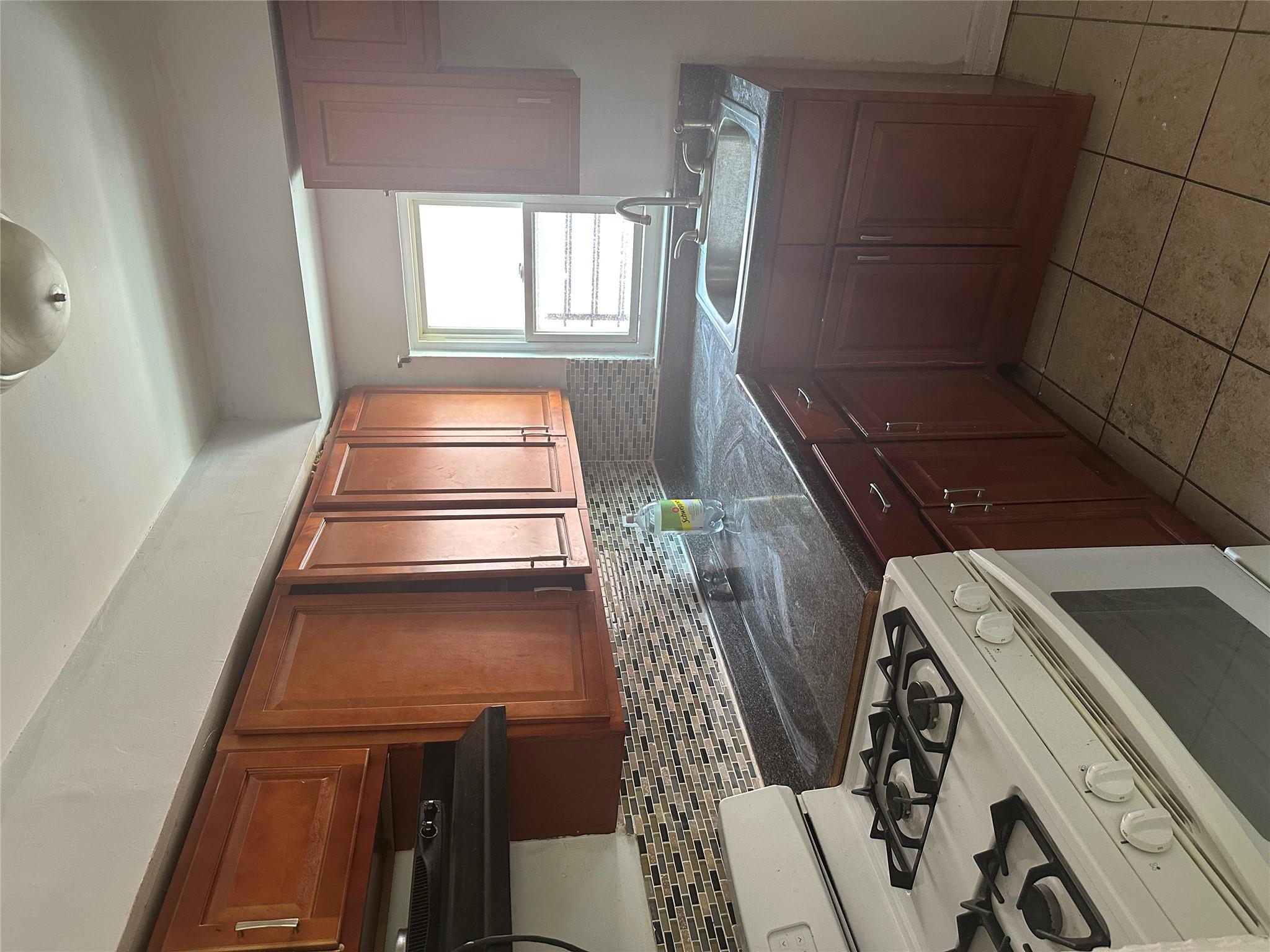 433 Howe Avenue, Unit A Bronx, NY 10473 - Photo 4 of 12 a kitchen with a stove sink and cabinets