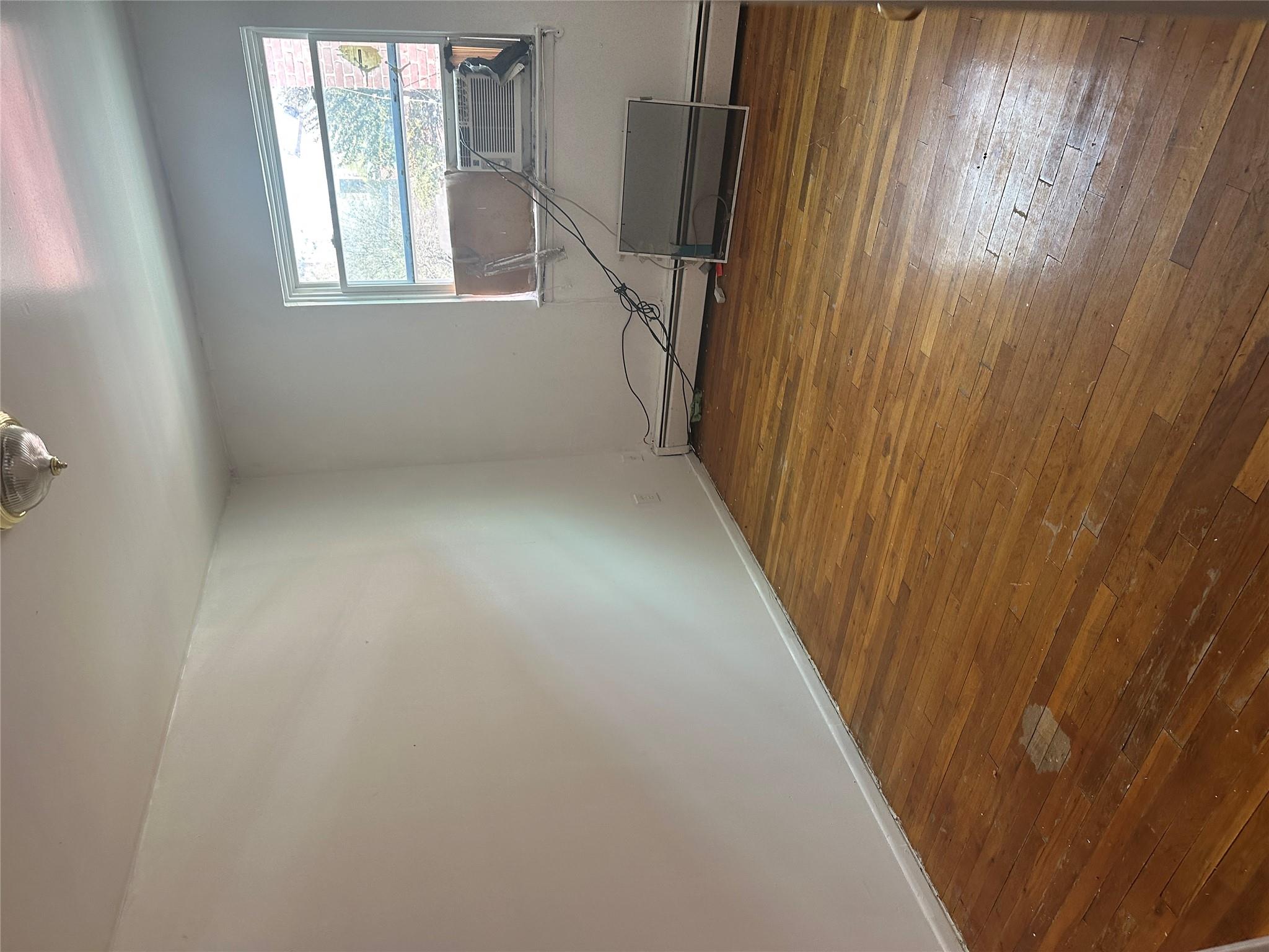 433 Howe Avenue, Unit A Bronx, NY 10473 - Photo 8 of 12 a room with a wooden floor and a window