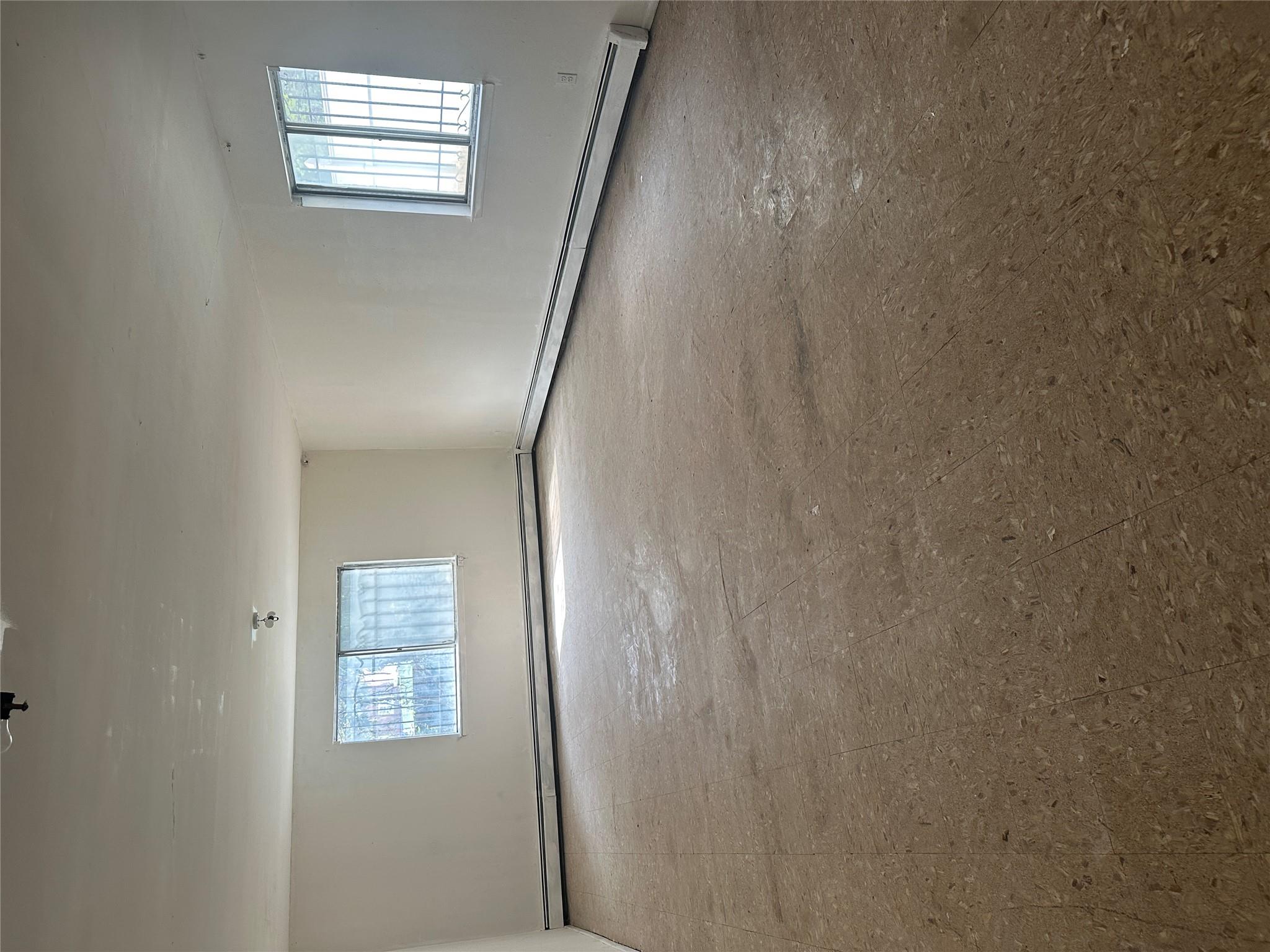 433 Howe Avenue, Unit A Bronx, NY 10473 - Photo 10 of 12 an empty room with windows and windows