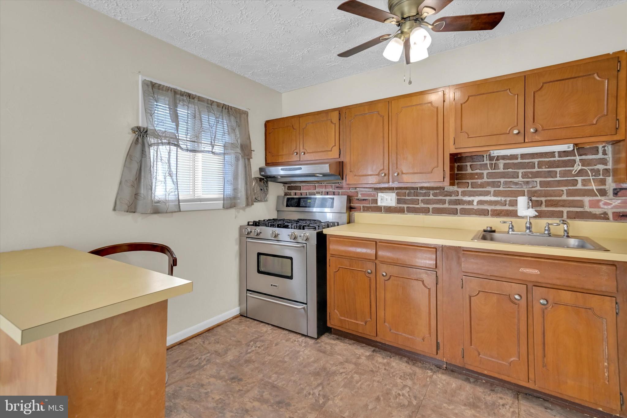 6812 Pepper Street Capitol Heights, MD 20743 - Photo 11 of 42 a kitchen with cabinets appliances and a window