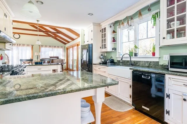 a kitchen with stainless steel appliances white cabinets and a window