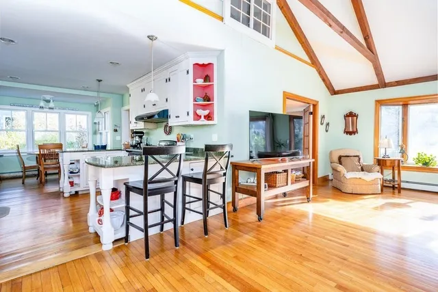 a kitchen with stainless steel appliances granite countertop a sink a stove and a wooden floors