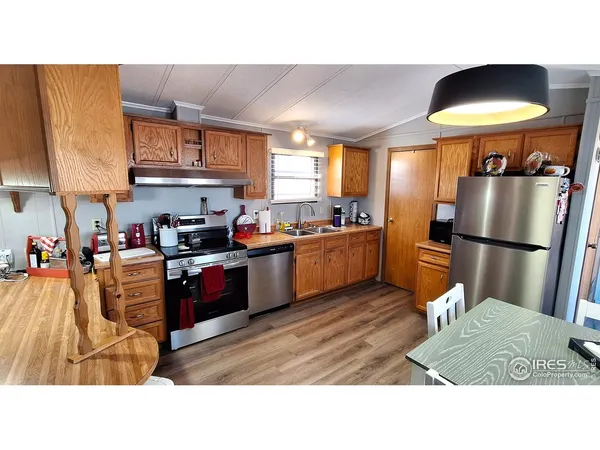 a kitchen with stainless steel appliances granite countertop a refrigerator a sink a stove and a refrigerator