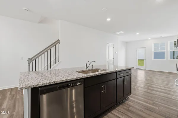 a kitchen with granite countertop stainless steel appliances a sink and cabinets