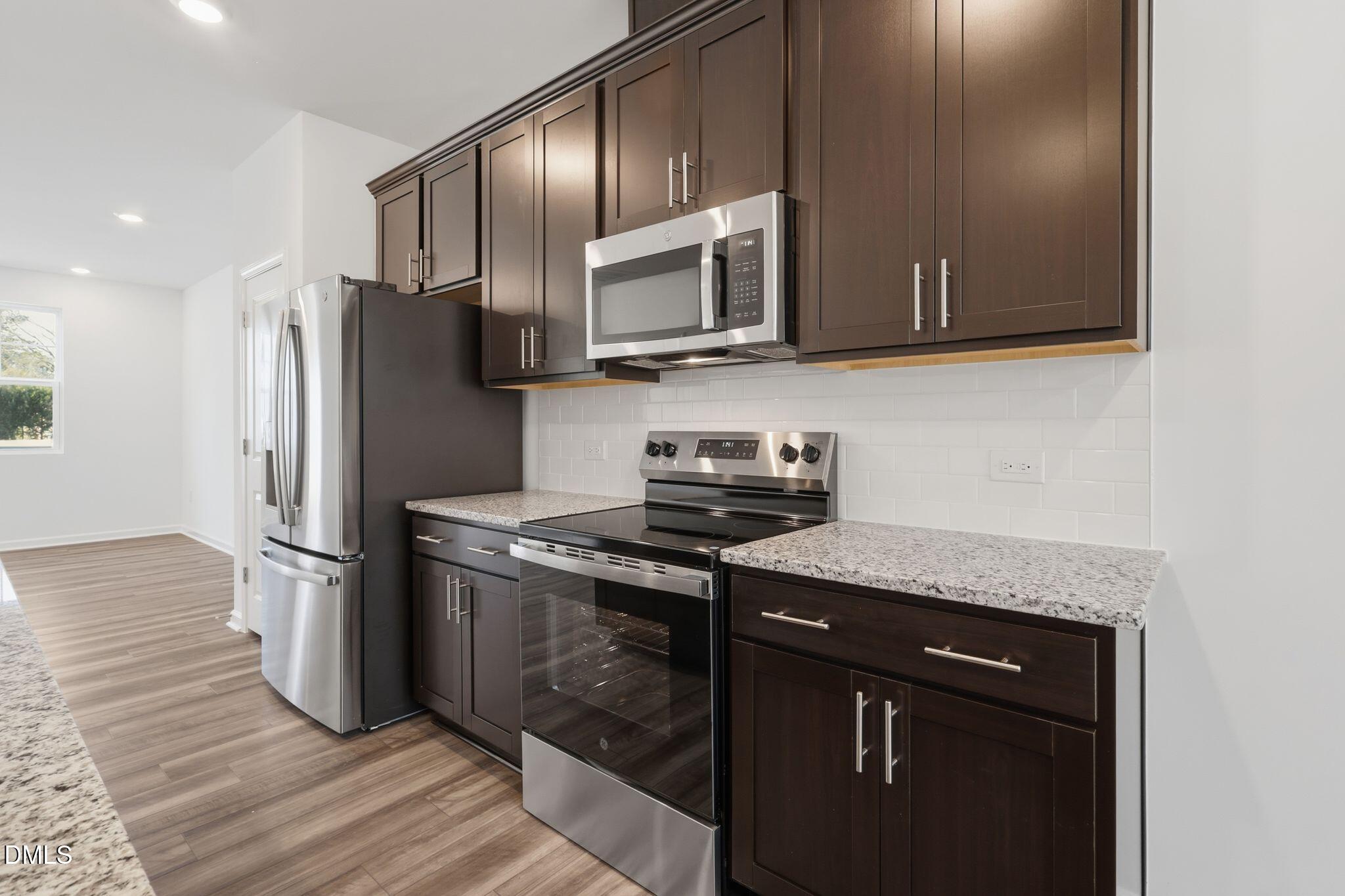 2309 Oakwood Mdws Court Raleigh, NC 27604 - Photo 16 of 34 a kitchen with stainless steel appliances granite countertop a stove a refrigerator and a microwave