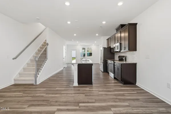 a view of kitchen with wooden floor and cabinets