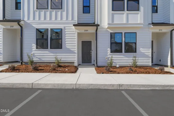 a front view of a house with garage and parking