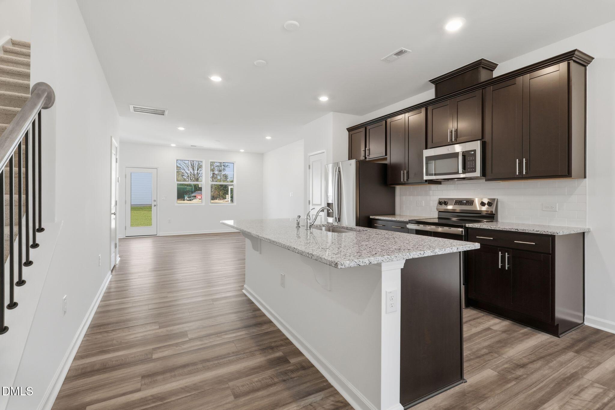 2309 Oakwood Mdws Court Raleigh, NC 27604 - Photo 21 of 34 a kitchen with stainless steel appliances granite countertop wooden cabinets a refrigerator and a stove top oven