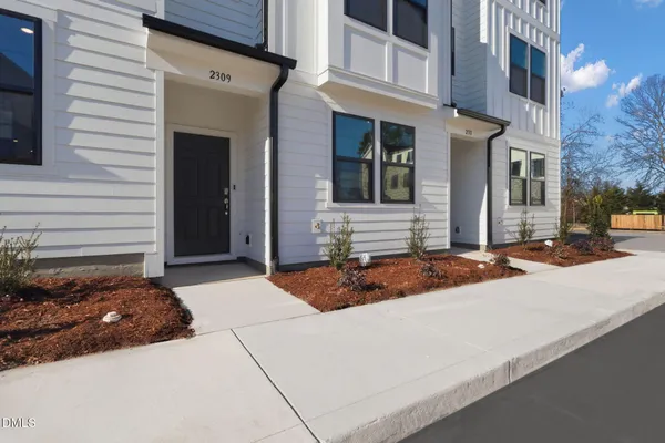 a view of a house with a yard and sitting area