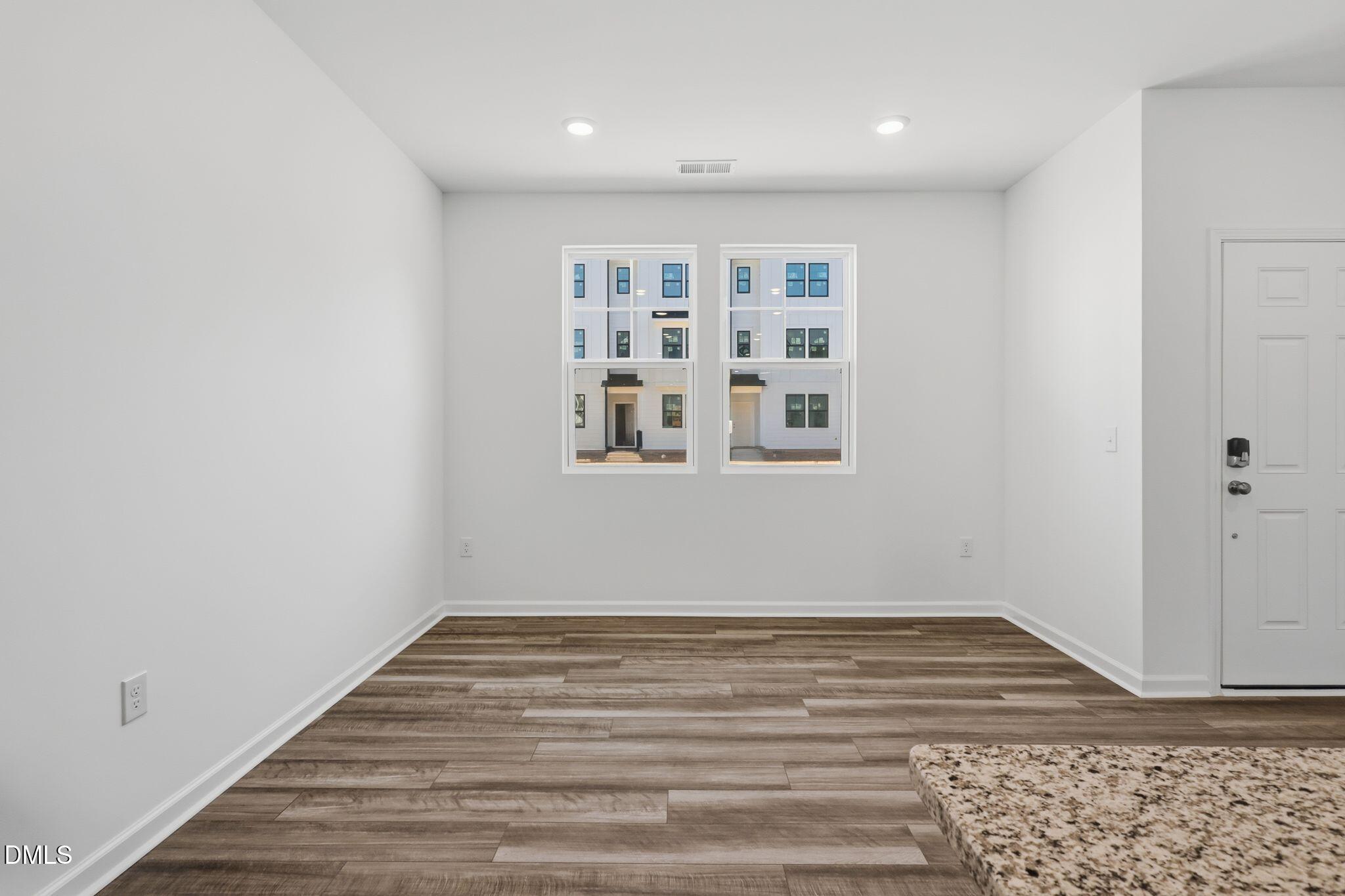 2309 Oakwood Mdws Court Raleigh, NC 27604 - Photo 5 of 34 a view of an empty room with wooden floor and a window