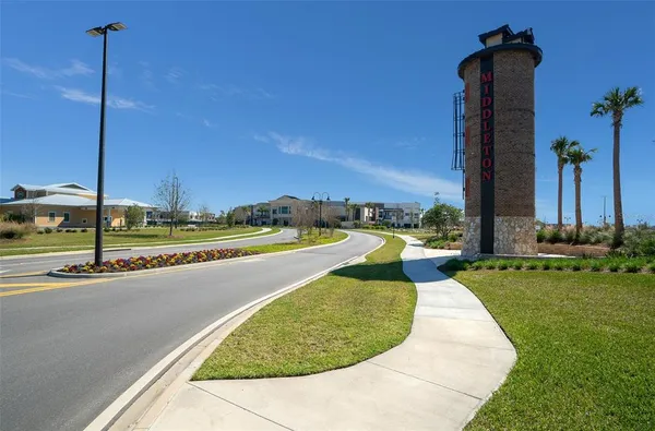 a view of a sign board with garden in the background