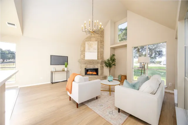 a living room with furniture a fireplace and a large mirror