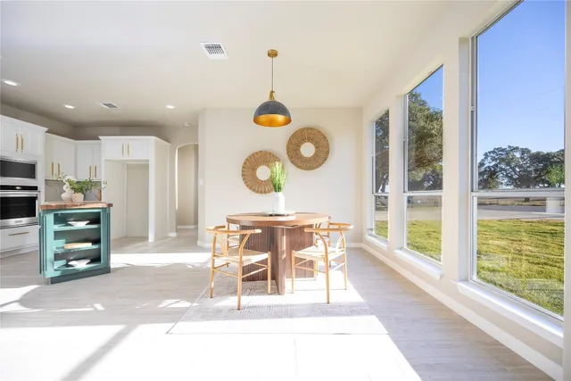 a view of a dining room and kitchen with a table windows and a fireplace