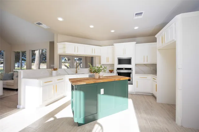 a kitchen with stainless steel appliances granite countertop a refrigerator a stove and a sink