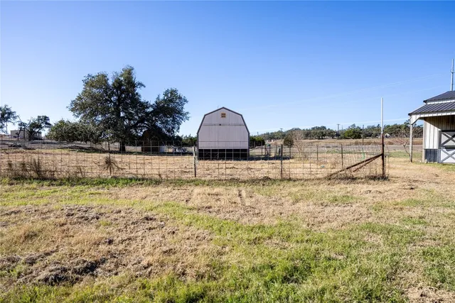 a view of a large yard with a house in the background