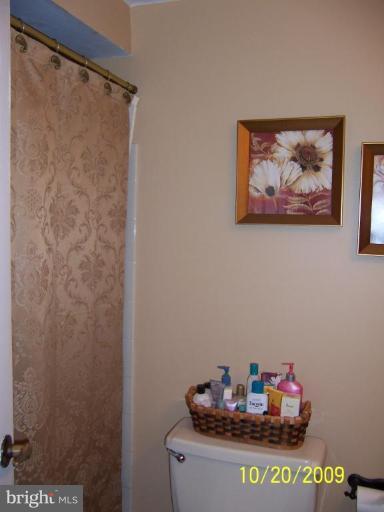9417 Gunview Road Nottingham, MD 21236 - Photo 11 of 30 a bathroom with a granite countertop sink a mirror and shower