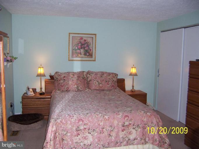 9417 Gunview Road Nottingham, MD 21236 - Photo 15 of 30 a large bed sitting in a bedroom next to a lamp with a rug