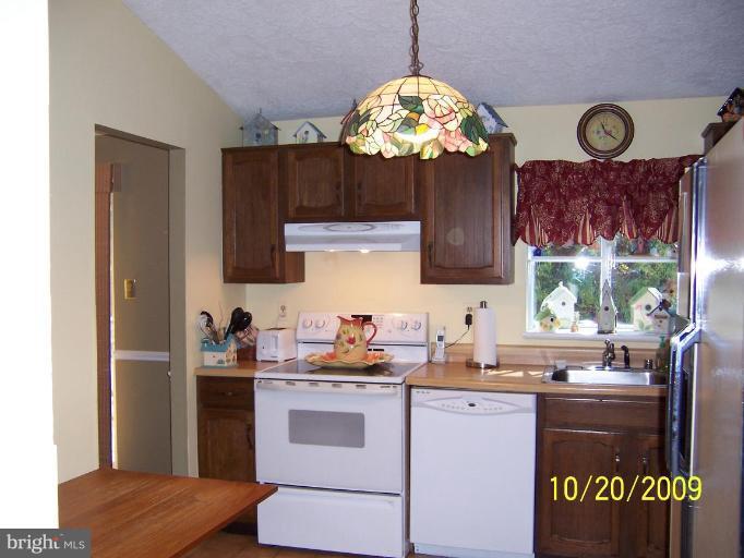 9417 Gunview Road Nottingham, MD 21236 - Photo 8 of 30 a kitchen with a refrigerator and a stove top oven