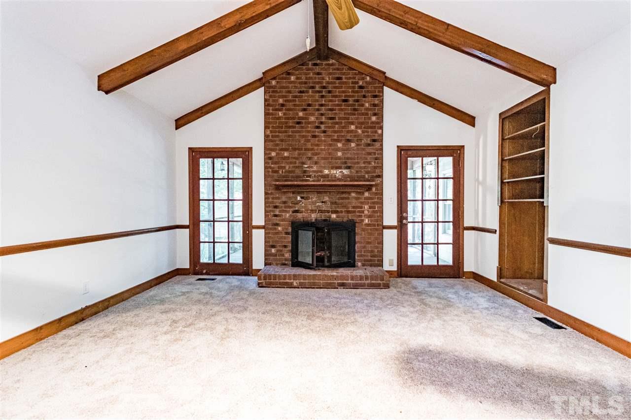 8700 Brandon Station Road Raleigh, NC 27613 - Photo 5 of 23 a view of an empty room with a fireplace and a window