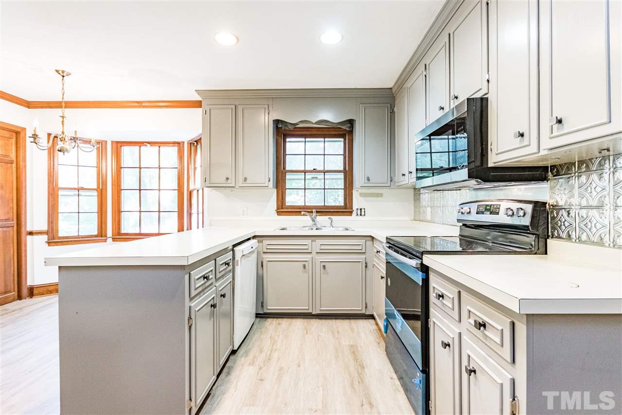 8700 Brandon Station Road Raleigh, NC 27613 - Photo 8 of 23 a kitchen with a sink stove and cabinets