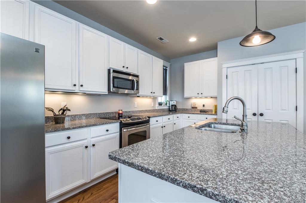3482 Richard's Crossing Fort Mill, SC 29708 - Photo 3 of 24 a kitchen with granite countertop a stove a sink a refrigerator and a microwave