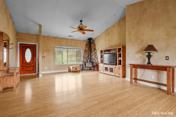 a view of an empty room with a window and wooden floor