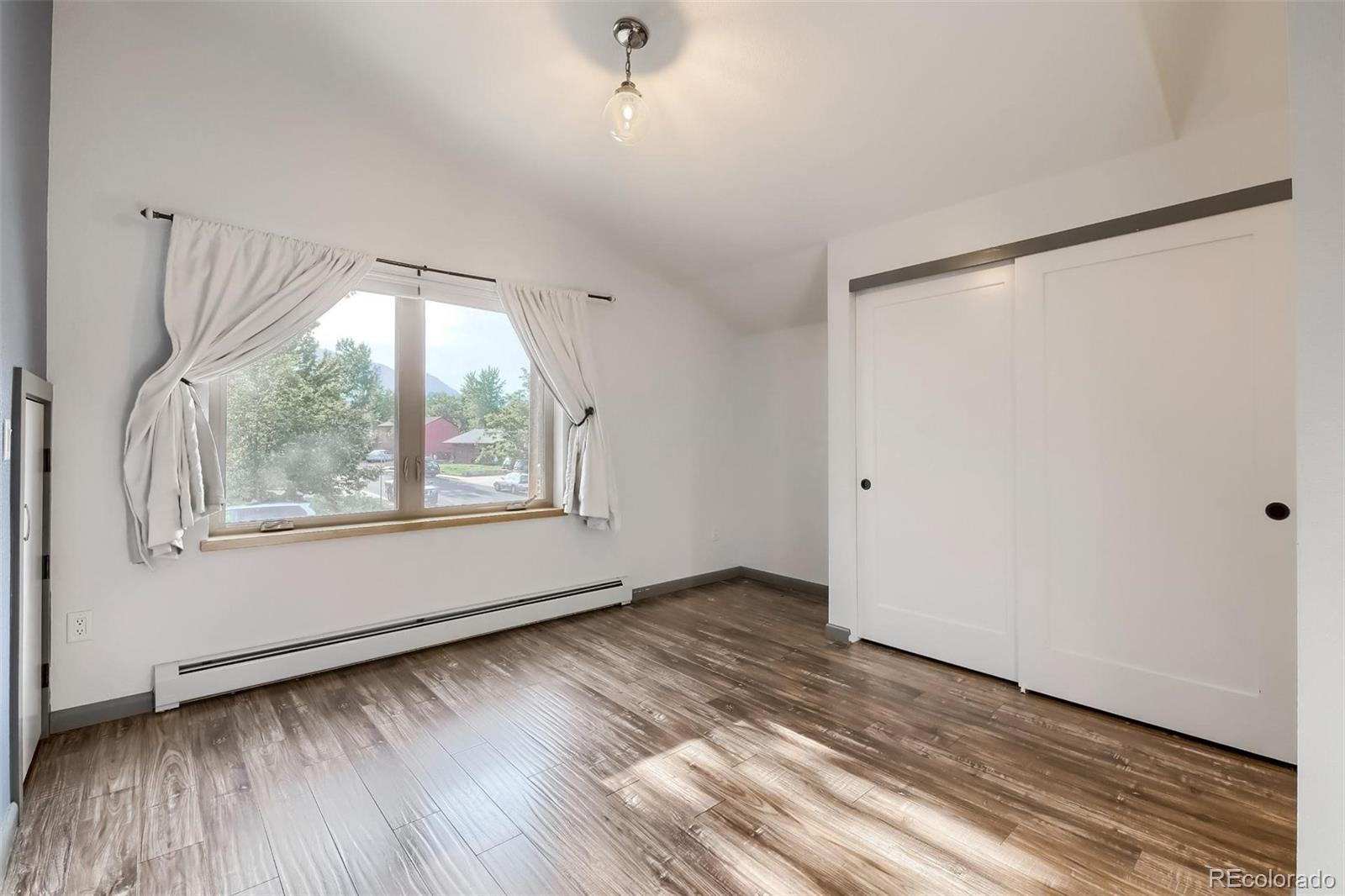 1320 Chambers Drive Boulder, CO 80305 - Photo 26 of 39 a view of an empty room with wooden floor and a window