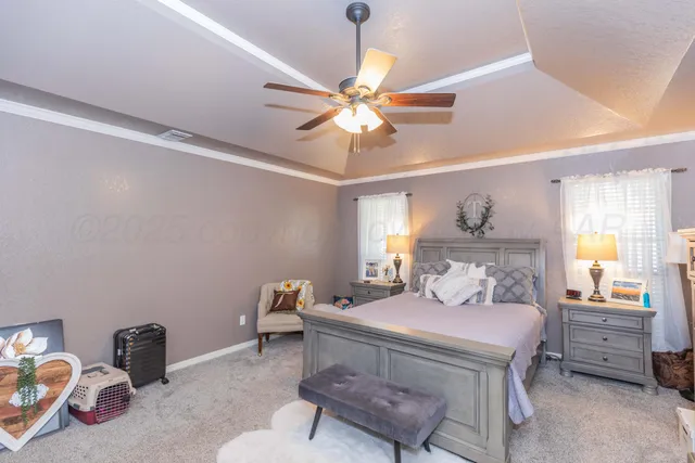 a bedroom with a bed and a chandelier fan