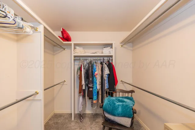 a view of walk in closet with clothes and shoes
