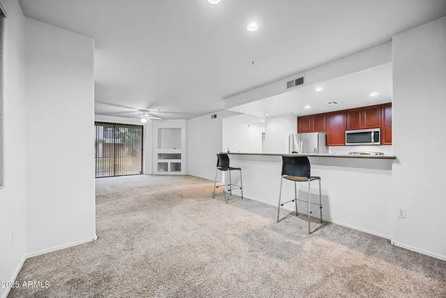 a kitchen with stainless steel appliances kitchen island granite countertop a stove a sink and a refrigerator