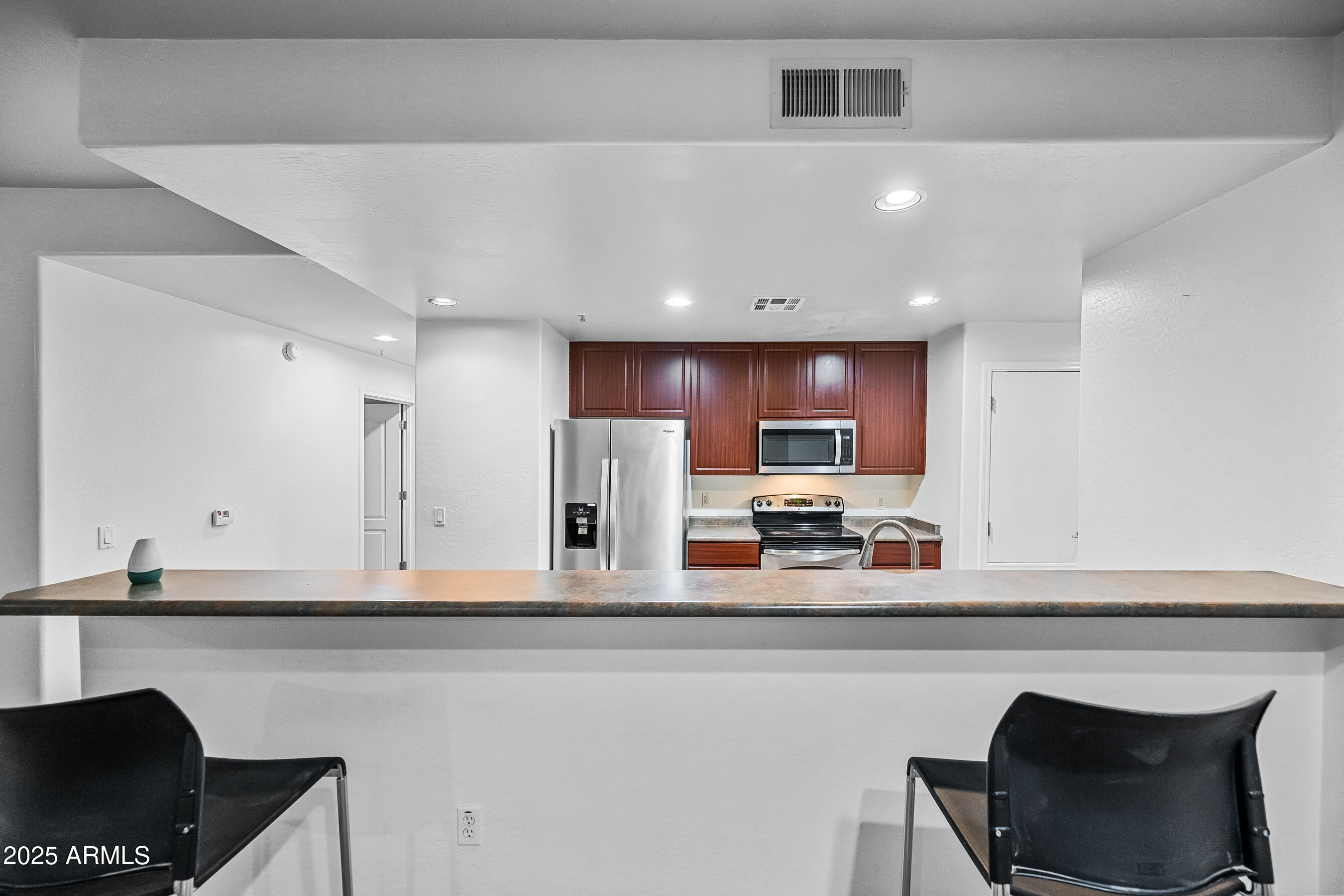 705 West Queen Creek Road, Unit 1079 Chandler, AZ 85248 - Photo 12 of 28 a kitchen with stainless steel appliances kitchen island granite countertop a stove a sink and a refrigerator