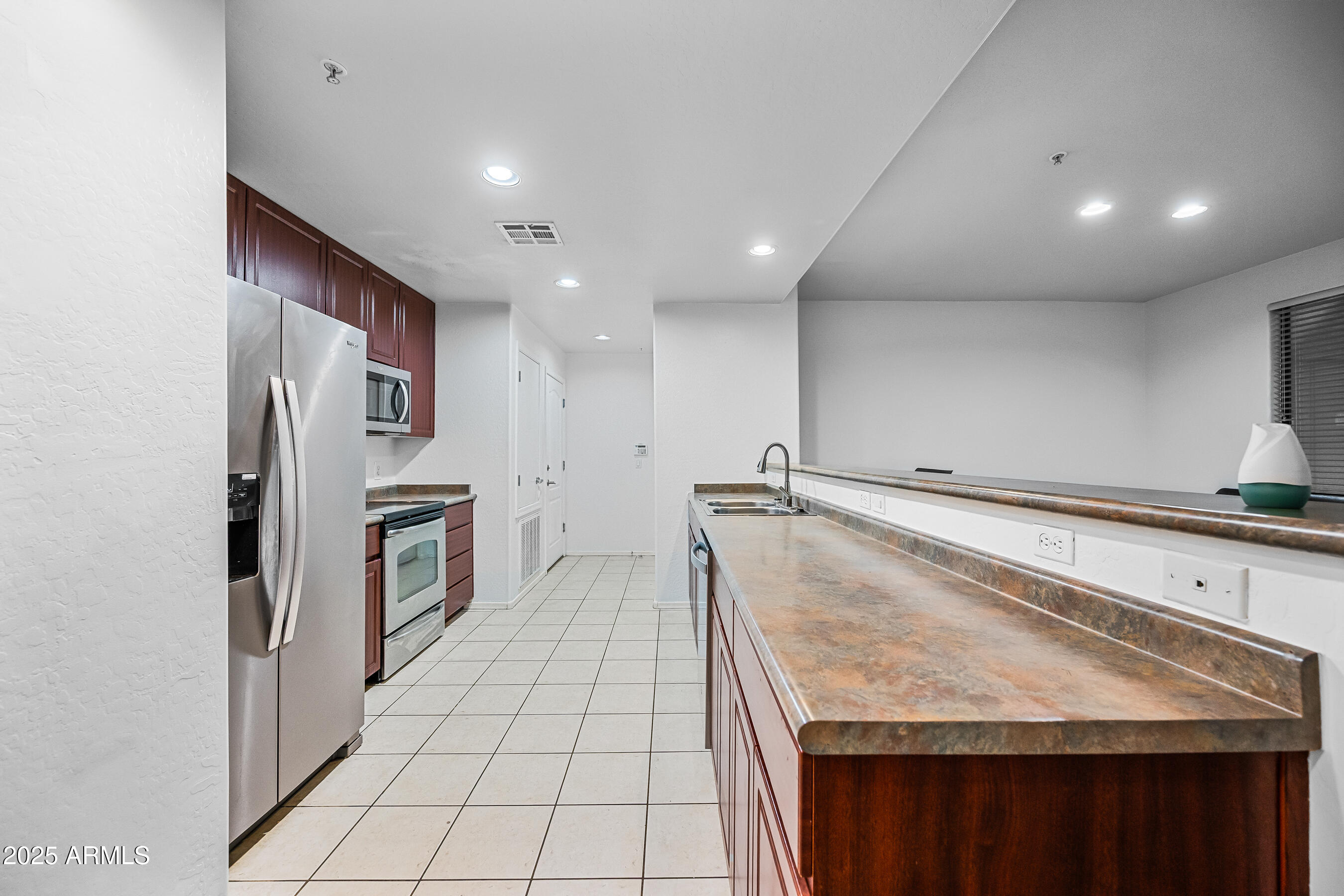 705 West Queen Creek Road, Unit 1079 Chandler, AZ 85248 - Photo 13 of 28 a kitchen with stainless steel appliances granite countertop a refrigerator and a stove top oven