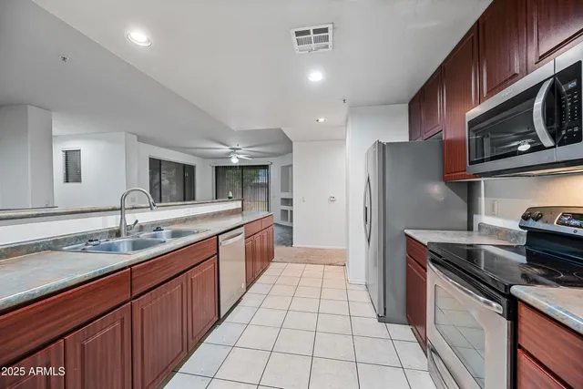 a kitchen with wooden cabinets and stainless steel appliances