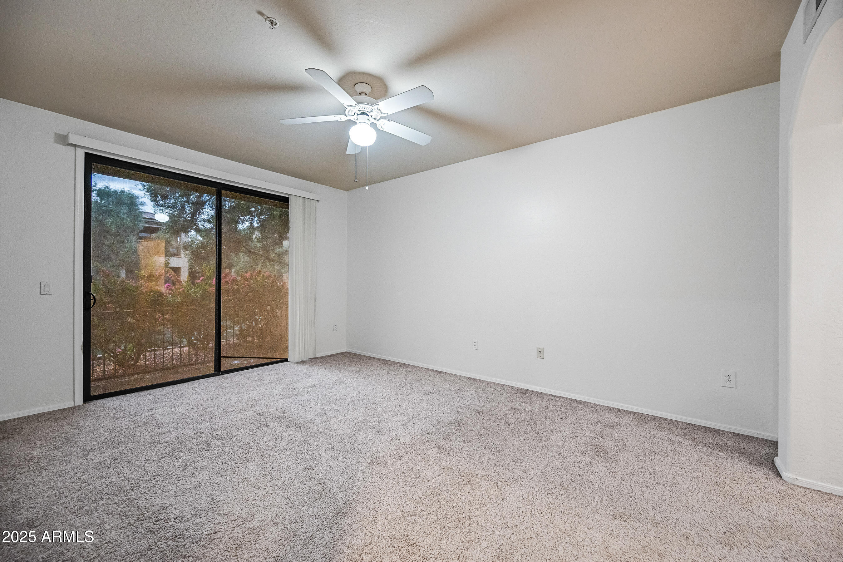 705 West Queen Creek Road, Unit 1079 Chandler, AZ 85248 - Photo 17 of 28 an empty room with chandelier fan and windows
