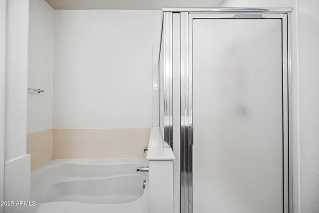 a spacious bathroom with a double vanity sink a mirror and a shower