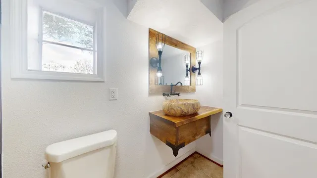 a bathroom with a toilet a sink and mirror