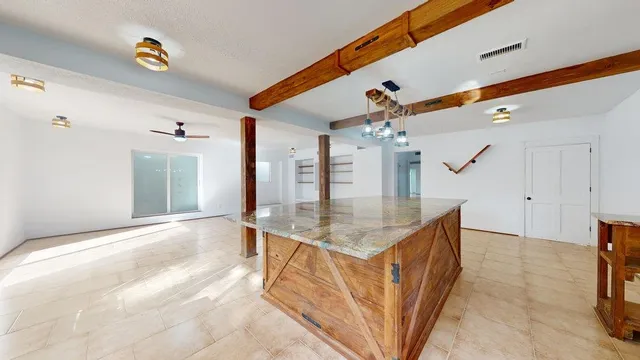 a kitchen with a sink a counter space and a chandelier