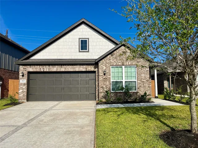 a front view of a house with a yard outdoor seating and garage
