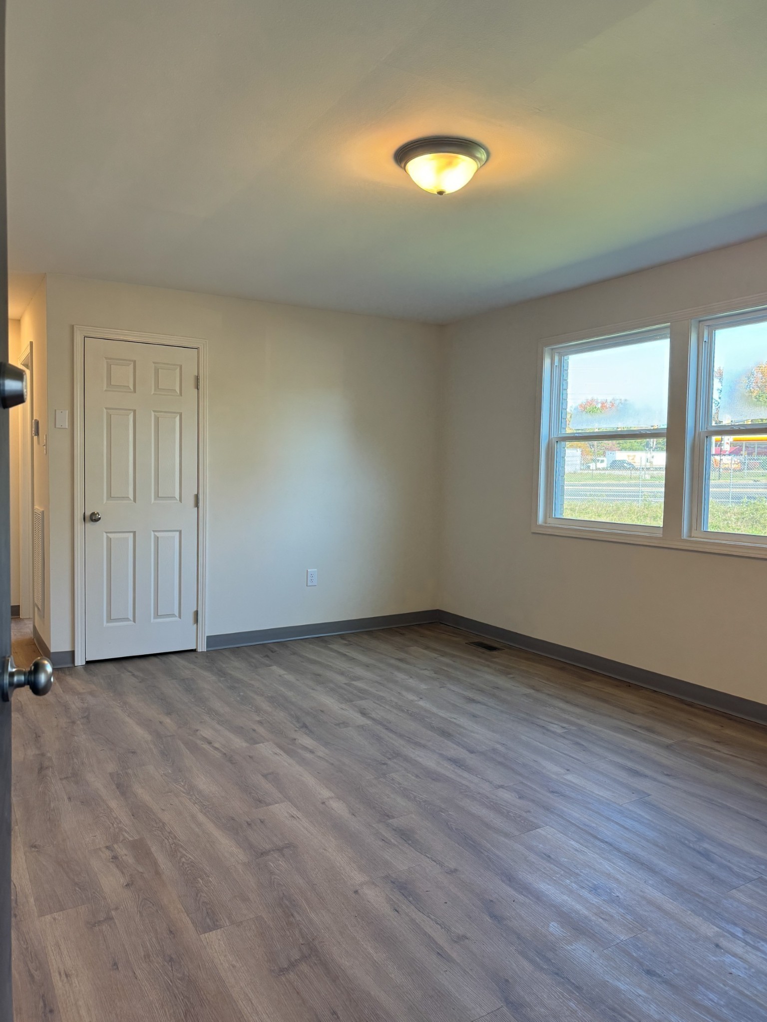 204 South Clydeton Road, Unit C Waverly, TN 37185 - Photo 13 of 14 an empty room with wooden floor and windows